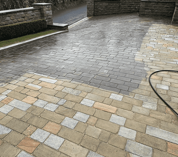 Large traditional steep hilly driveway befitting a large estate in the middle of being power washed