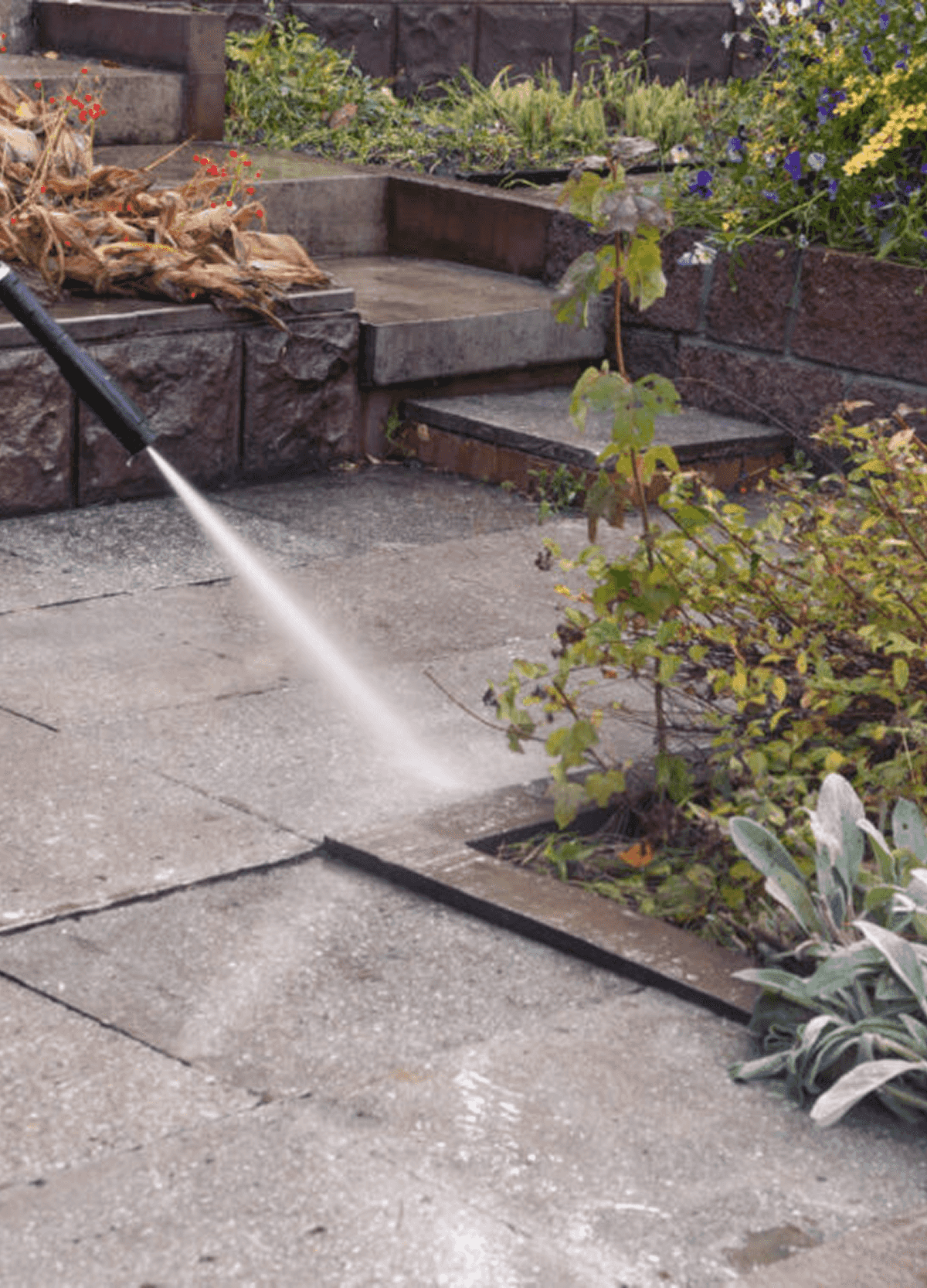 A power hose power washing a patio